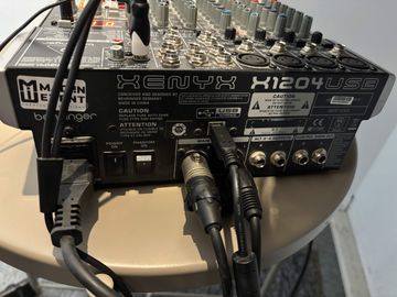 Console de mixage douze entrées, câblée, portant un autocollant au logo de Mad’in Event.